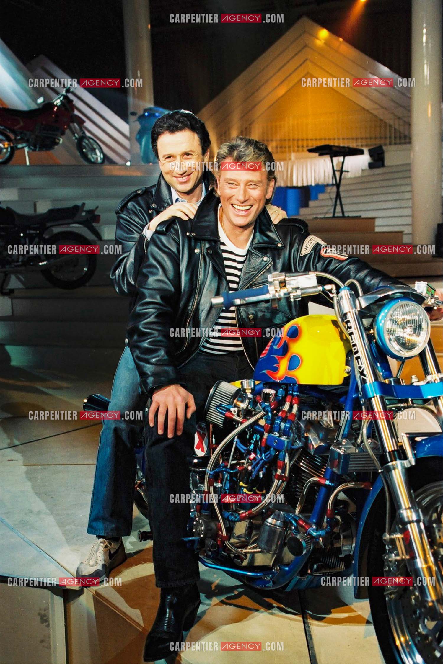 Répétitions de l'émission “ Stars 90“ avec comme invité Johnny Hallyday et présentée par Michel Drucker ensemble sur une Harley Davidson.  ( Exclusif )
