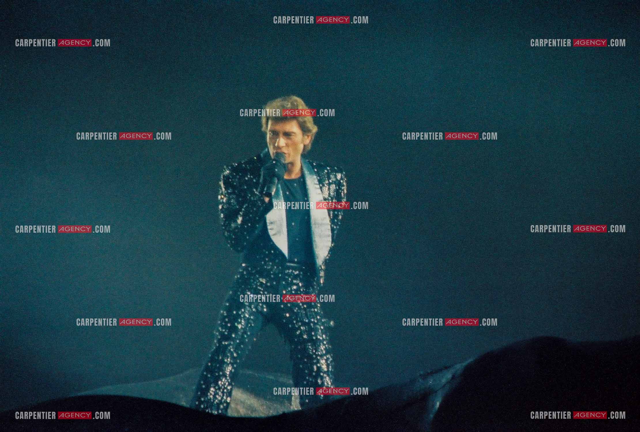L'entrée de scène à l'intérieur d'un gant s'ouvrant et balayant la salle de gauche à droite du chanteur Johnny Hallyday en concert au Zénith de Paris du 26 octobre 1984 au 8 janvier 1985.  ( Exclusif )