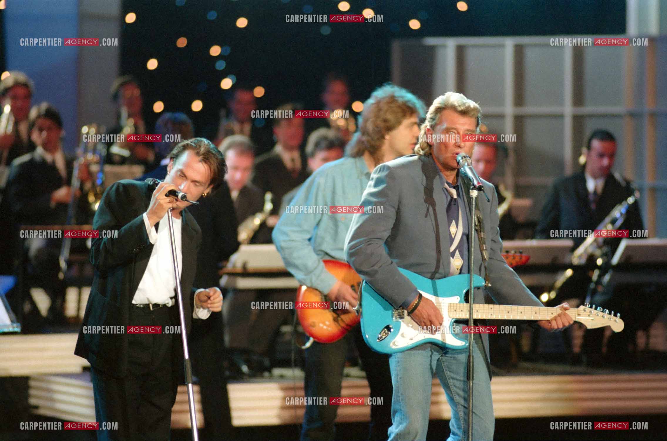 Le chanteur Johnny Hallyday accompagné de son guitariste Thibault Abrial en duo avec Florent Pagny pour l'enregistrement de l'émission “ Sacrée Soirée “ sur TF1 en 1992.    ( Exclusif ).