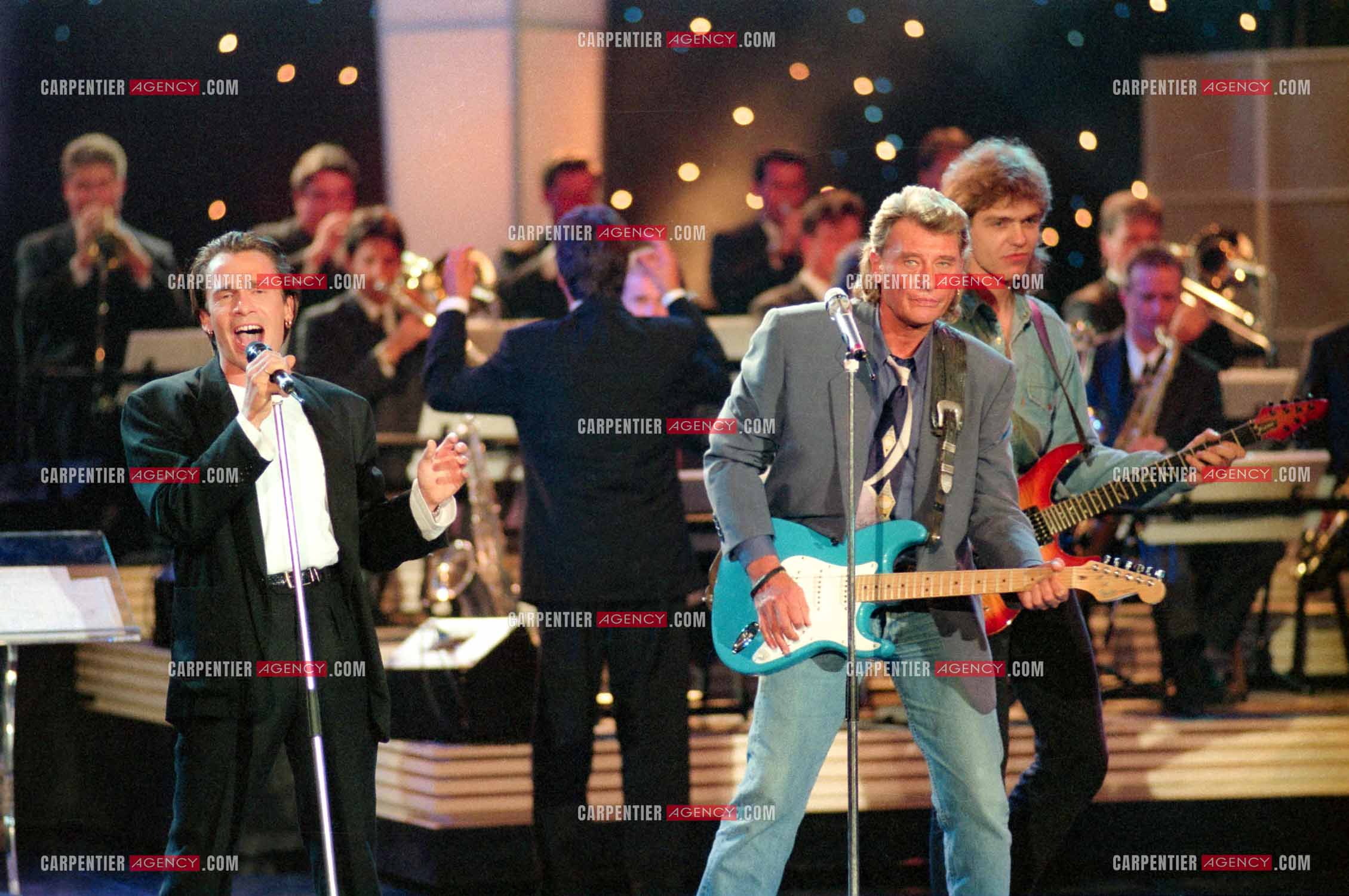 Le chanteur Johnny Hallyday accompagné de son guitariste Thibault Abrial en duo avec Florent Pagny pour l'enregistrement de l'émission “ Sacrée Soirée “ sur TF1 en 1992.    ( Exclusif ).