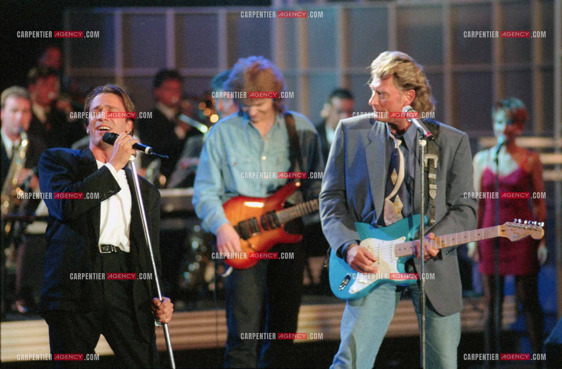 Le chanteur Johnny Hallyday accompagné de son guitariste Thibault Abrial en duo avec Florent Pagny pour l'enregistrement de l'émission “ Sacrée Soirée “ sur TF1 en 1992.    ( Exclusif ).