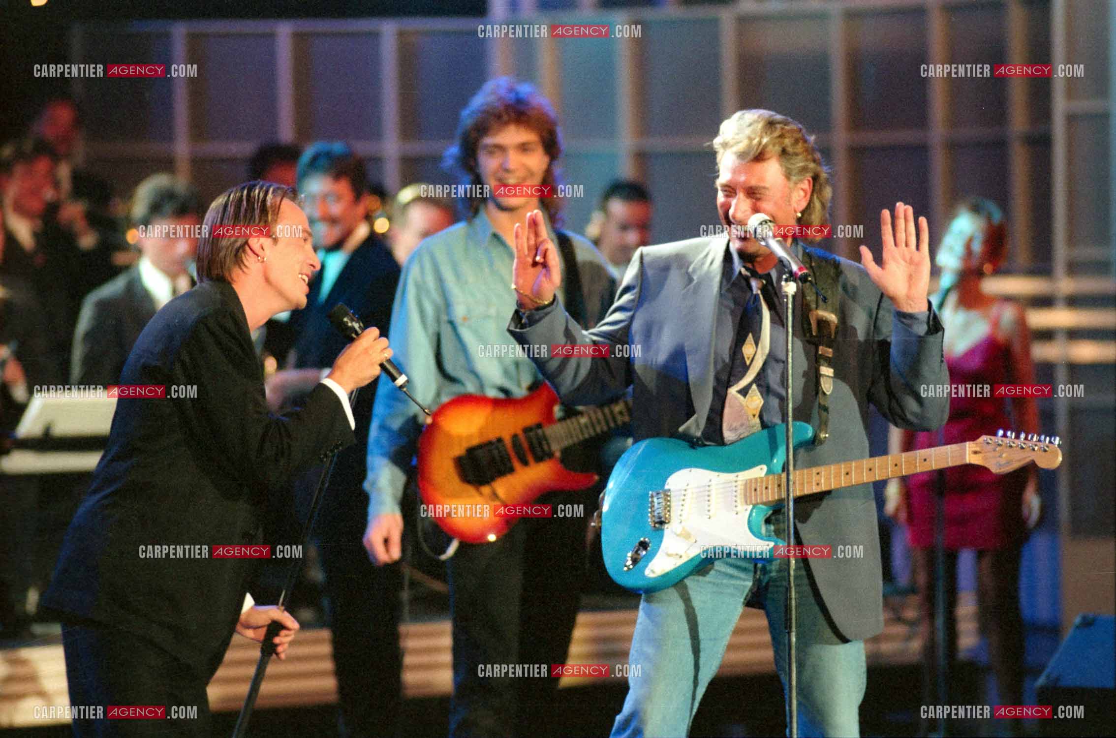 Le chanteur Johnny Hallyday accompagné de son guitariste Thibault Abrial en duo avec Florent Pagny pour l'enregistrement de l'émission “ Sacrée Soirée “ sur TF1 en 1992.    ( Exclusif ).