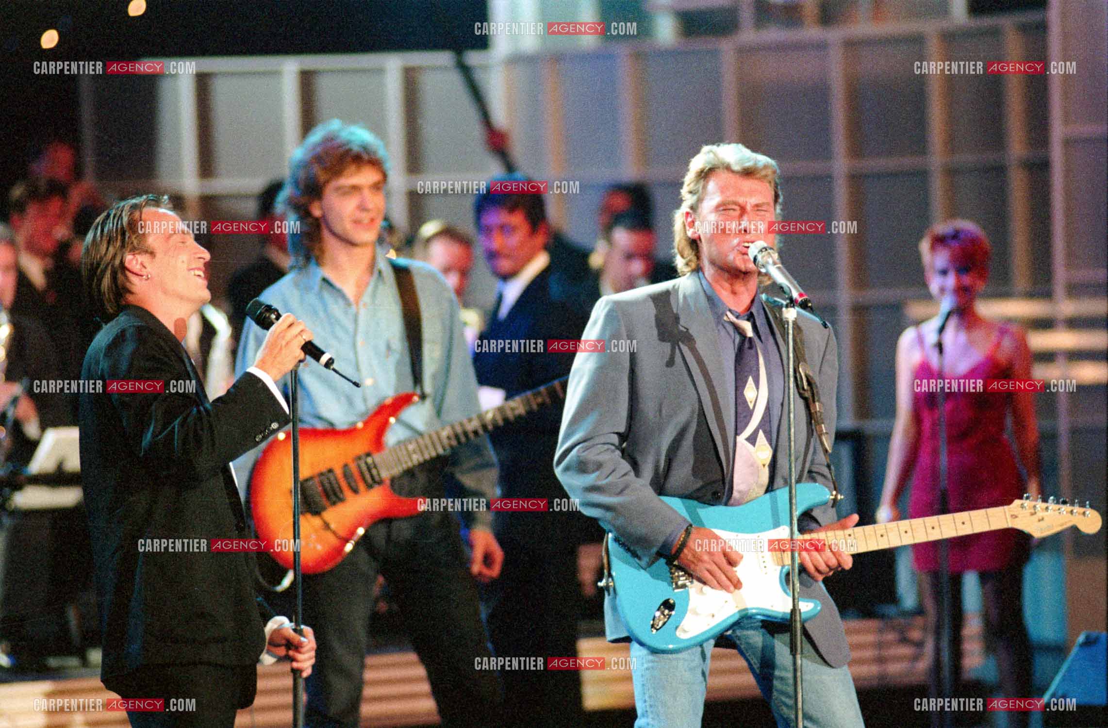 Le chanteur Johnny Hallyday accompagné de son guitariste Thibault Abrial en duo avec Florent Pagny pour l'enregistrement de l'émission “ Sacrée Soirée “ sur TF1 en 1992.    ( Exclusif ).