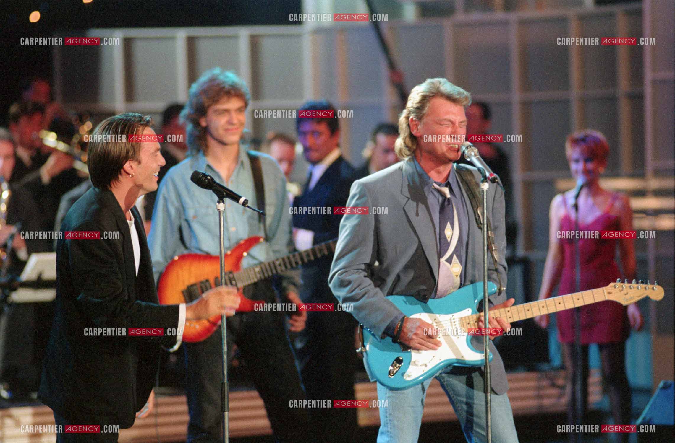 Le chanteur Johnny Hallyday accompagné de son guitariste Thibault Abrial en duo avec Florent Pagny pour l'enregistrement de l'émission “ Sacrée Soirée “ sur TF1 en 1992.    ( Exclusif ).