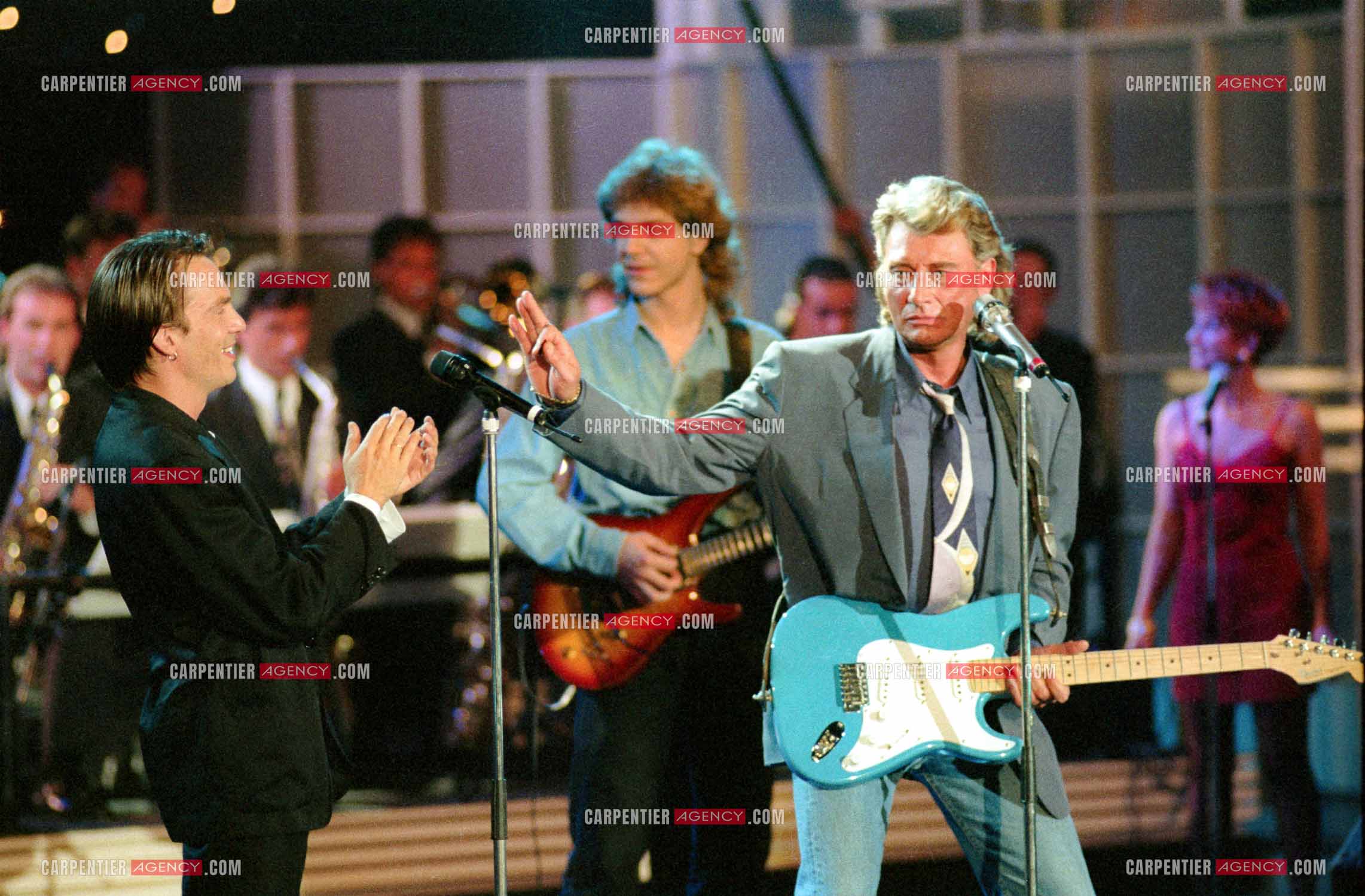 Le chanteur Johnny Hallyday accompagné de son guitariste Thibault Abrial en duo avec Florent Pagny pour l'enregistrement de l'émission “ Sacrée Soirée “ sur TF1 en 1992.    ( Exclusif ).