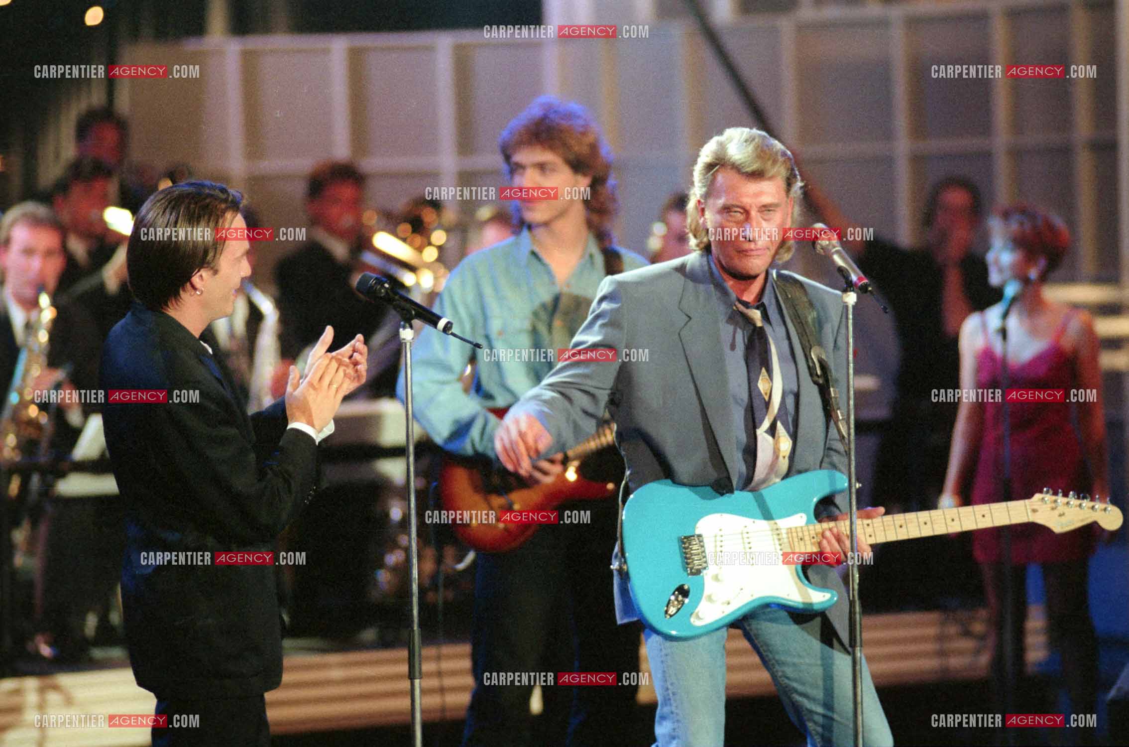 Le chanteur Johnny Hallyday accompagné de son guitariste Thibault Abrial en duo avec Florent Pagny pour l'enregistrement de l'émission “ Sacrée Soirée “ sur TF1 en 1992.    ( Exclusif ).