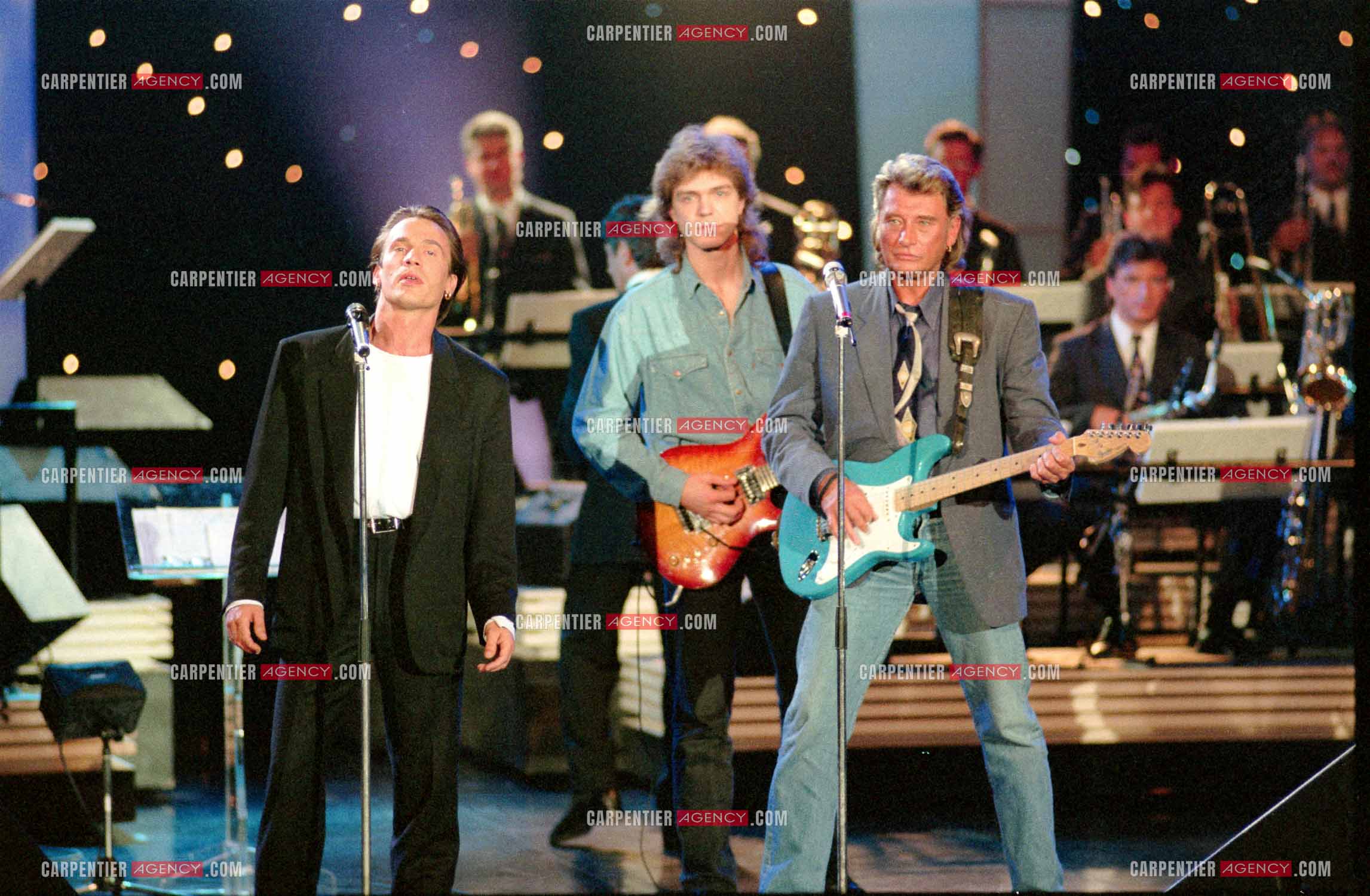 Le chanteur Johnny Hallyday accompagné de son guitariste Thibault Abrial en duo avec Florent Pagny pour l'enregistrement de l'émission “ Sacrée Soirée “ sur TF1 en 1992.    ( Exclusif ).