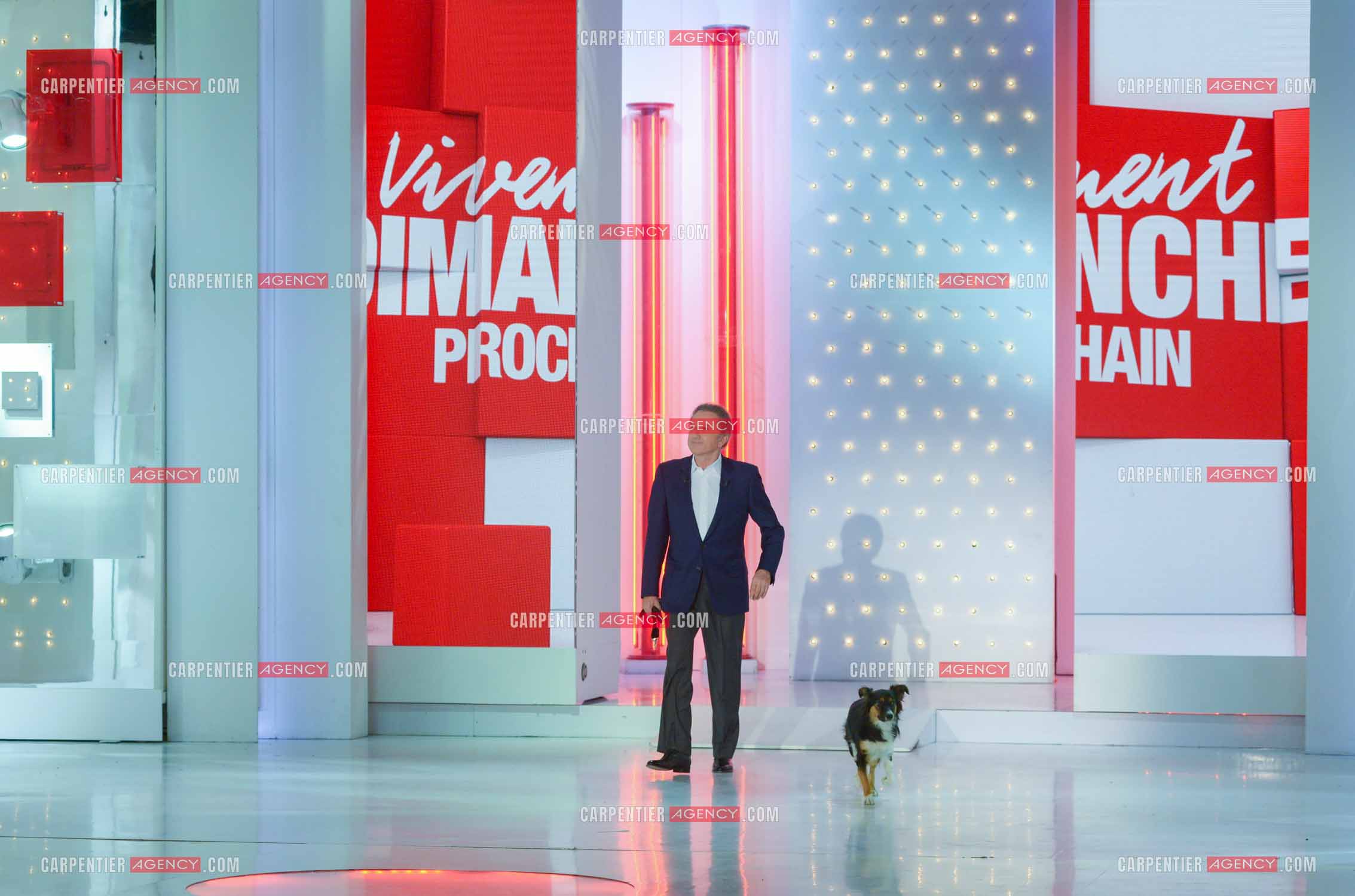 L'animateur Michel Drucker accompagné de sa chienne Izia sur le plateau de son émission Vivement Dimanche..
