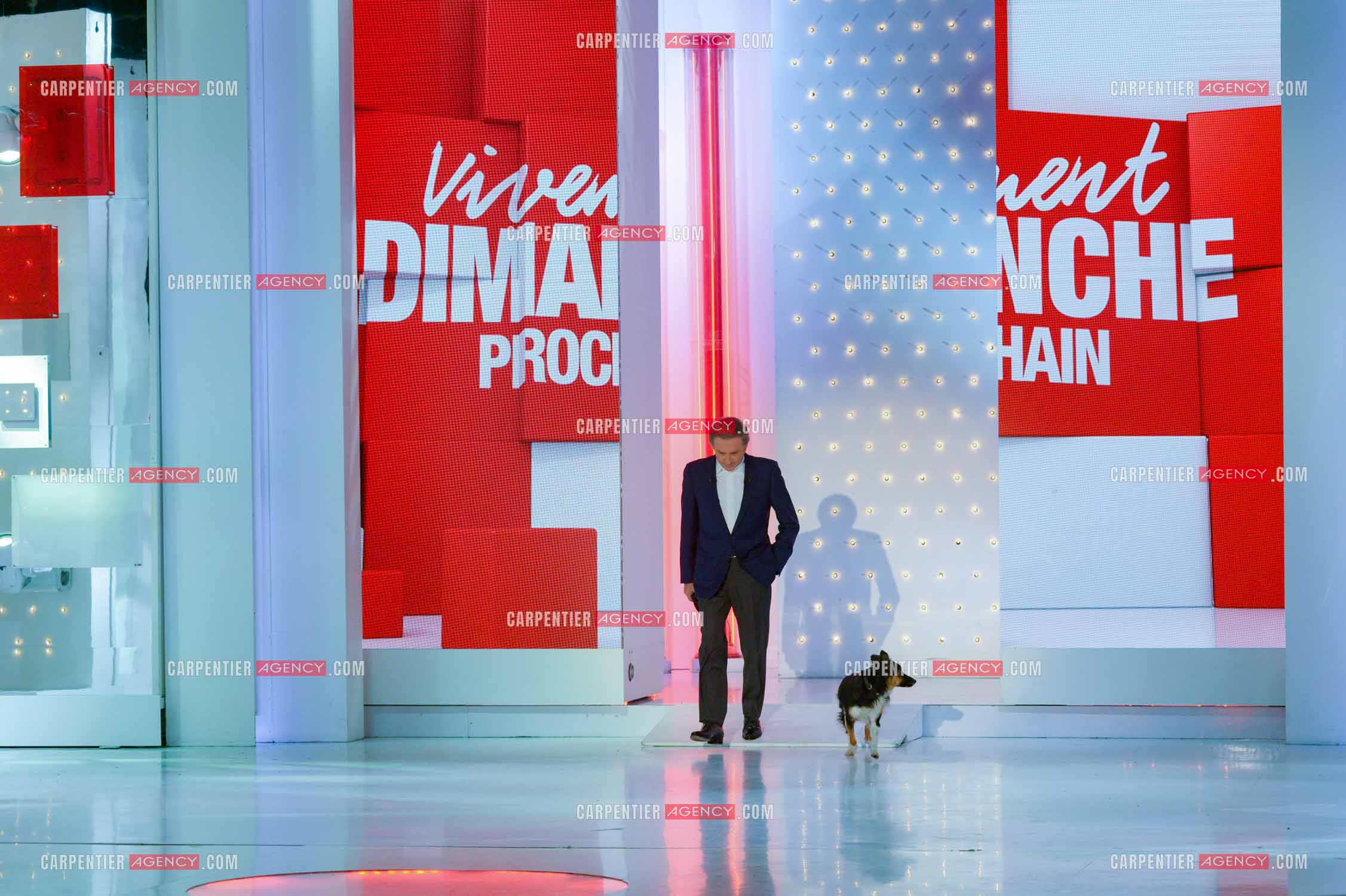 L'animateur Michel Drucker accompagné de sa chienne Izia sur le plateau de son émission Vivement Dimanche..