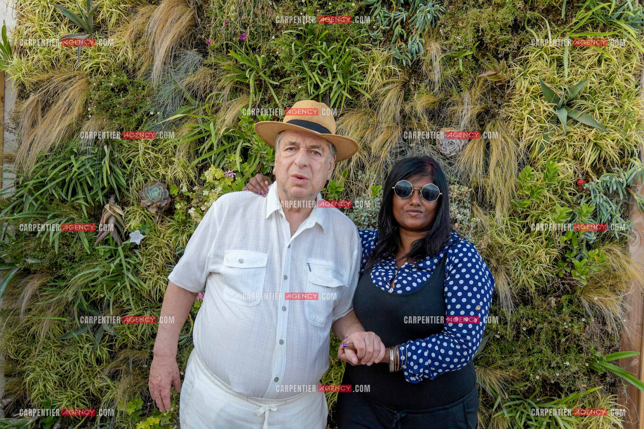 Paul-Loup Sulitzer lors d'une ballade sur le port de St Tropez. Ici en terrasse du bar de plage le " TAHAITI “  avec sa compagne  Supriya Answya Devi Rathoar.  ( Exclusif )