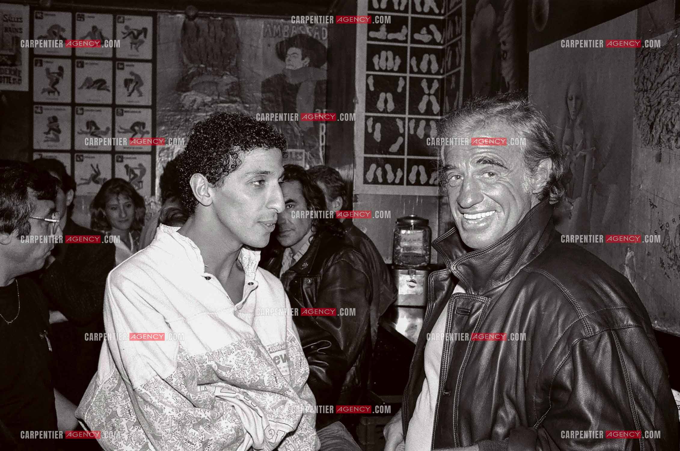 L'humoriste Smaïn  reçoit Jean-Paul Belmondo au bar de l'Olympia chez Marilyn avant d'assister à son One Man Show " T'EN VEUX ? " en 1989.   ( Exclusif )