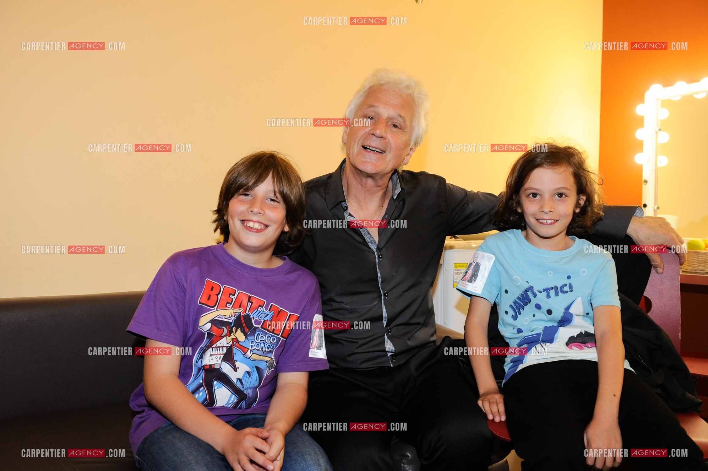 Le chanteur Gérard Lenorman dans sa loge entouré de ses deux petits enfants.     ( Exclusif )