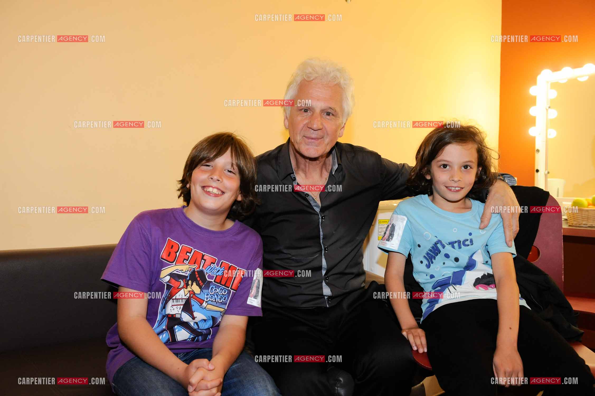 Le chanteur Gérard Lenorman dans sa loge entouré de ses deux petits enfants.     ( Exclusif )