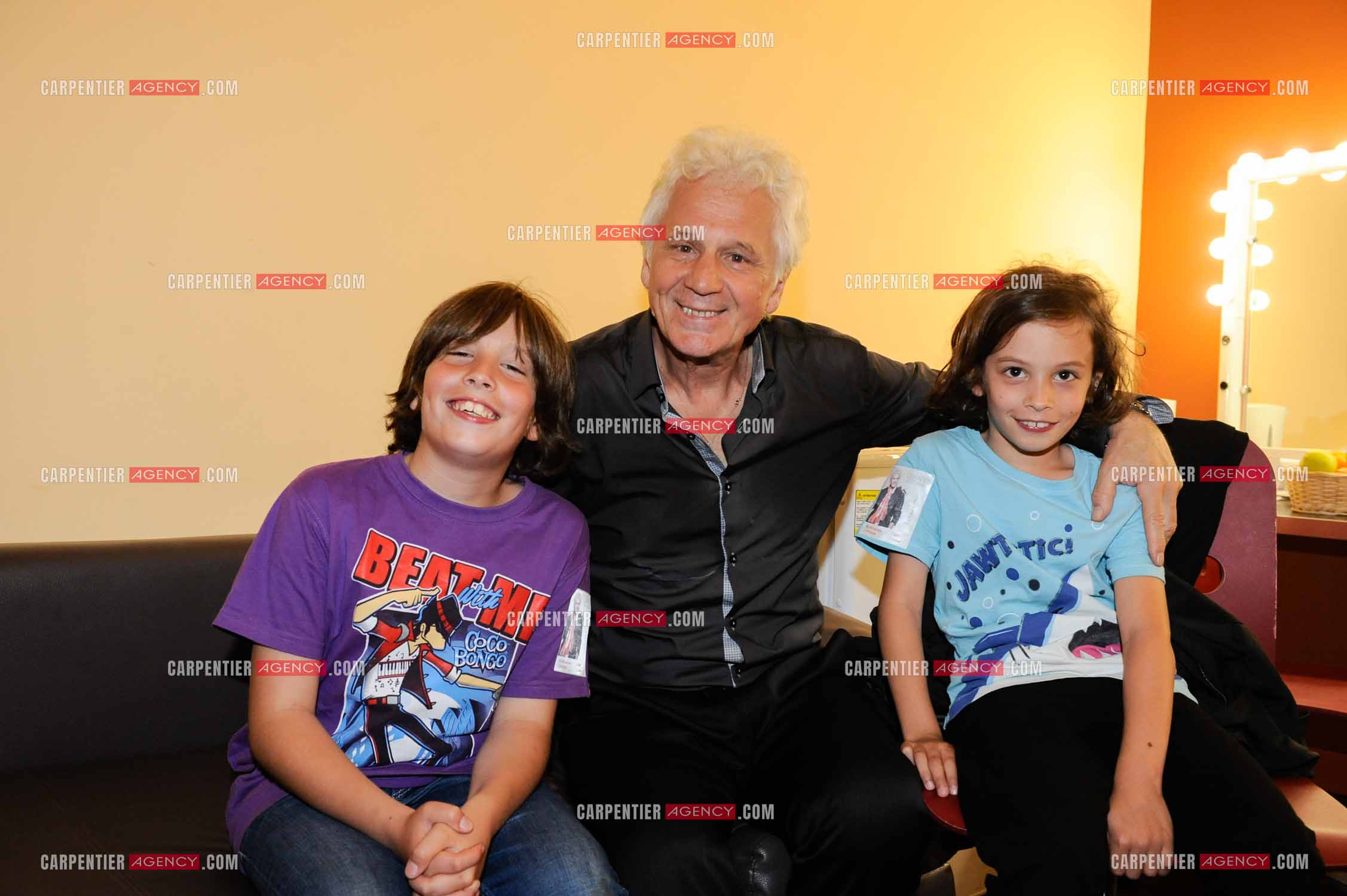 Le chanteur Gérard Lenorman dans sa loge entouré de ses deux petits enfants.     ( Exclusif )