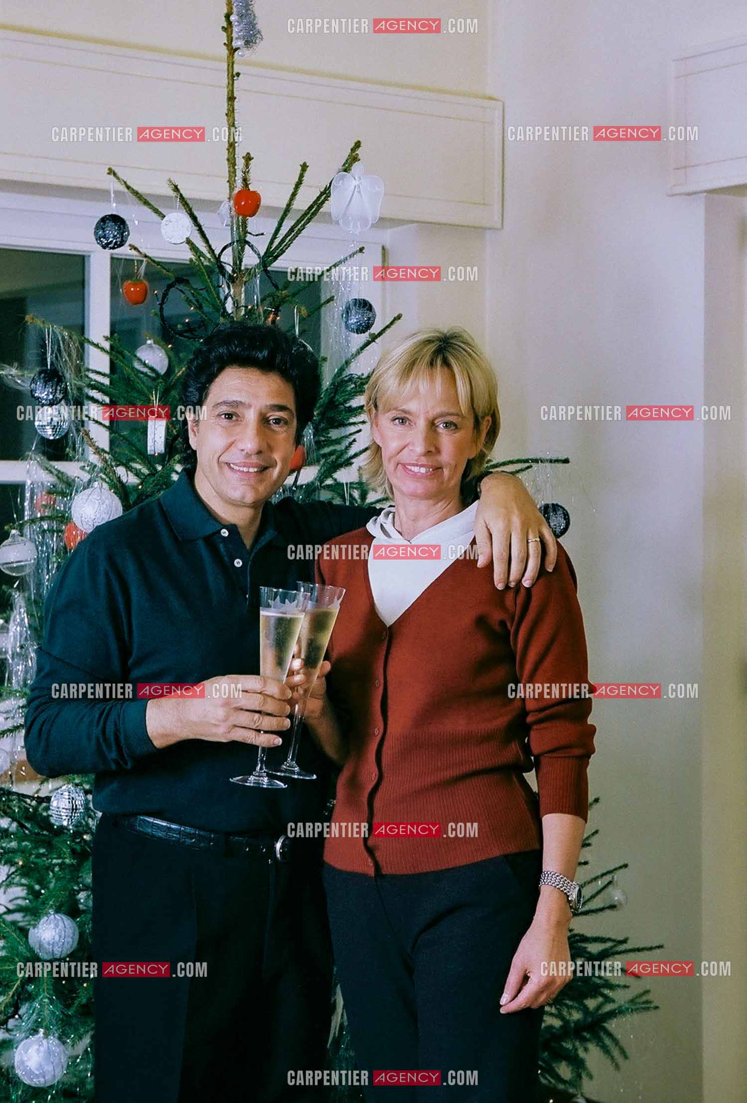 Le chanteur Frédéric François chez lui en Belgique se prépare à fêter Noël en famille autour du sapin. Frédéric et sa femme Monique trinquent pour annoncer les fêtes.  ( Exclusif )