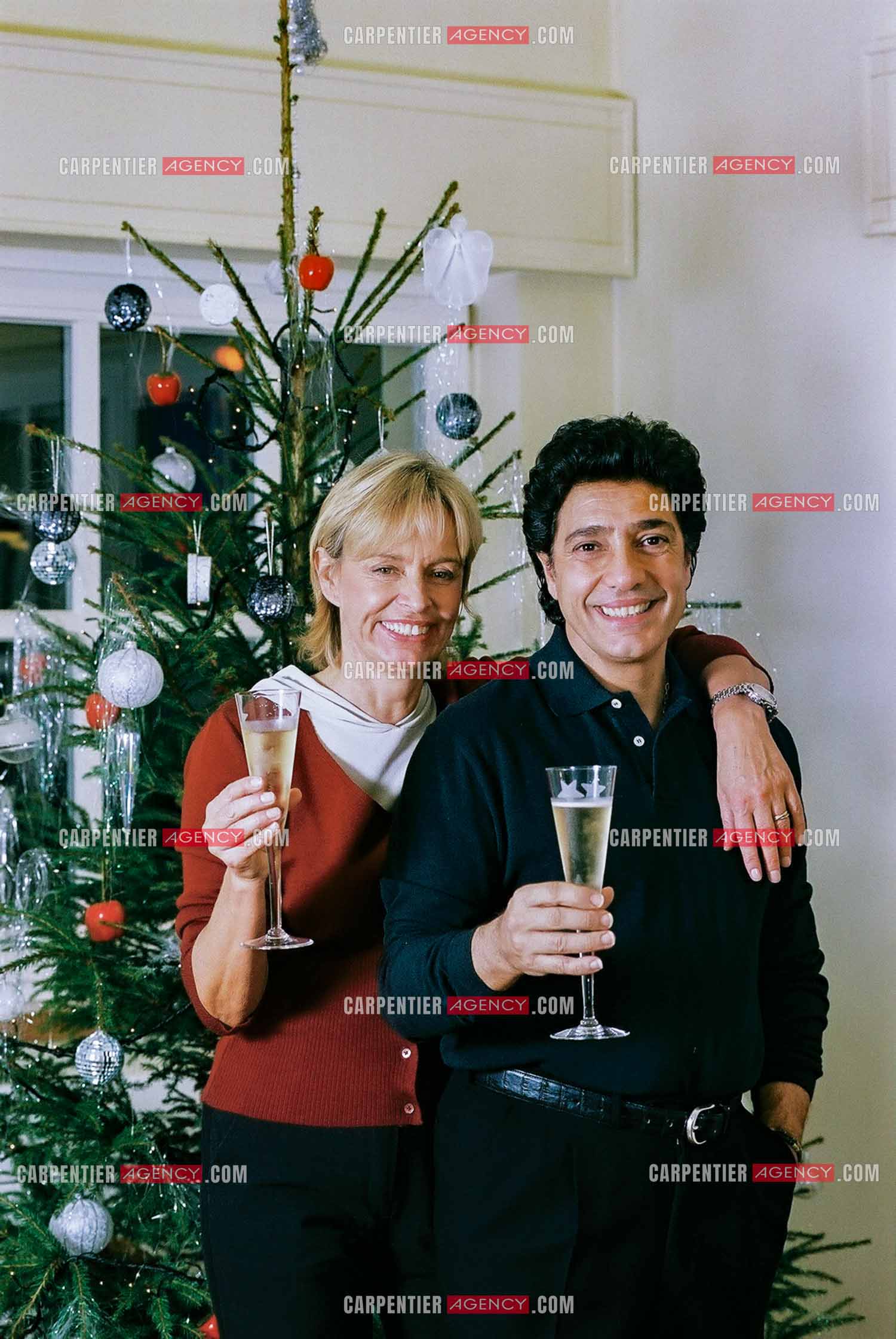 Le chanteur Frédéric François chez lui en Belgique se prépare à fêter Noël en famille autour du sapin. Frédéric et sa femme Monique trinquent pour annoncer les fêtes.  ( Exclusif )