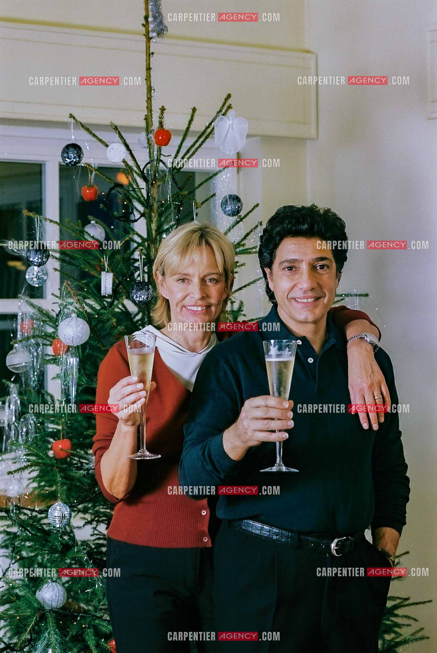 Le chanteur Frédéric François chez lui en Belgique se prépare à fêter Noël en famille autour du sapin. Frédéric et sa femme Monique trinquent pour annoncer les fêtes.  ( Exclusif )