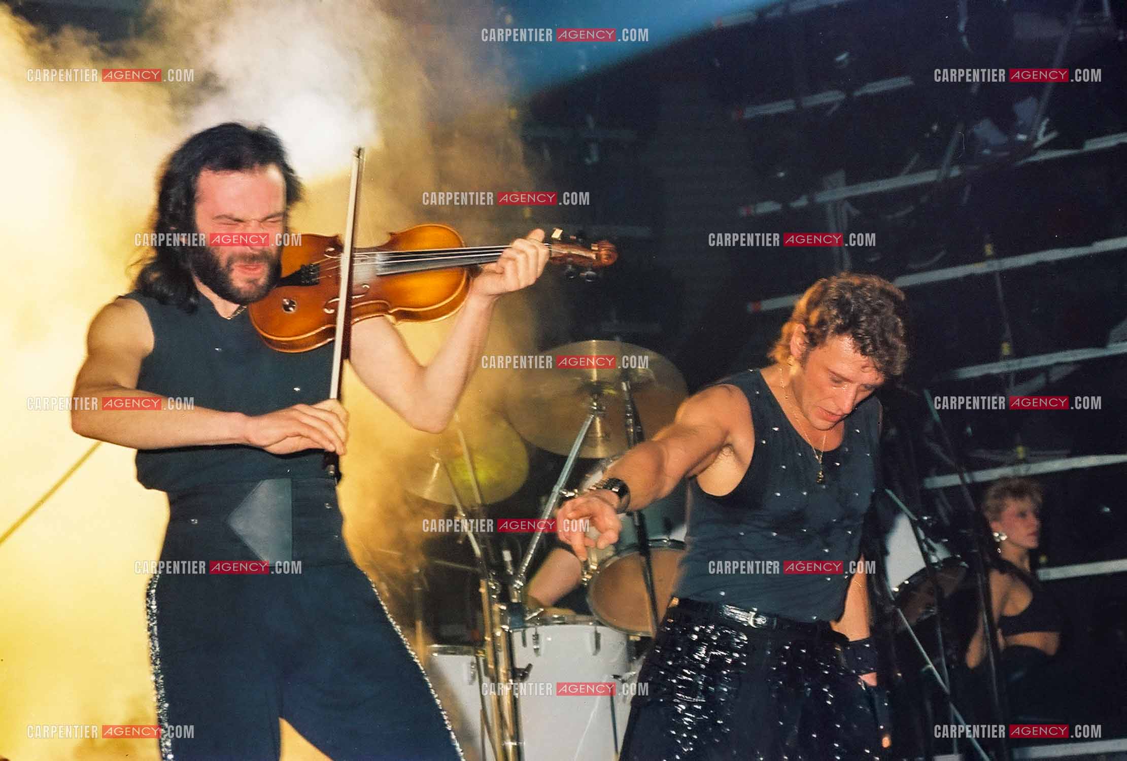 Le chanteur Johnny Hallyday en concert au Zénith de Paris du 26 octobre 1984 au 8 janvier 1985. Johnny et son violoniste Jean-Jacques Évrard pour le titre “Entre Violence et Violon“( Exclusif )